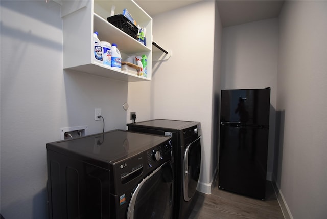 laundry room with washing machine and dryer, baseboards, wood finished floors, and laundry area