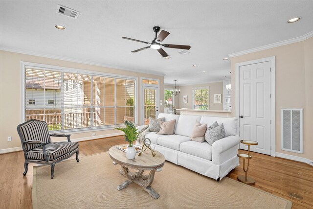 living room featuring crown molding, ceiling fan, recessed lighting, baseboards, and wood finished floors