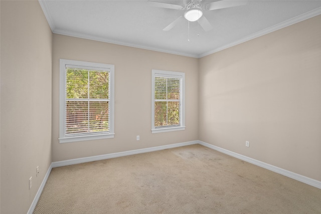 unfurnished room featuring light colored carpet, ornamental molding, baseboards, and a ceiling fan