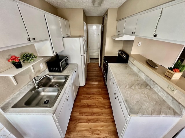 12660 Ashford Point Dr Unit 302, Houston, TX 77082 - kitchen featuring electric range, a textured ceiling, black microwave, wood finished floors, and a sink