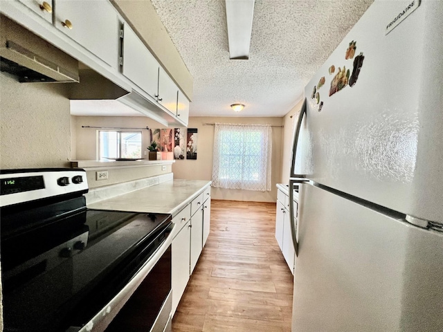 12660 Ashford Point Dr Unit 302, Houston, TX 77082 - kitchen with freestanding refrigerator, stainless steel electric range, a textured ceiling, and a wealth of natural light