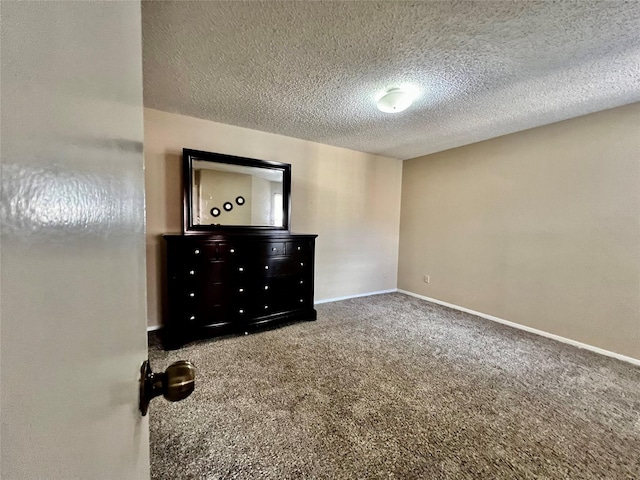 12660 Ashford Point Dr Unit 302, Houston, TX 77082 - unfurnished bedroom featuring carpet floors, a textured ceiling, and baseboards