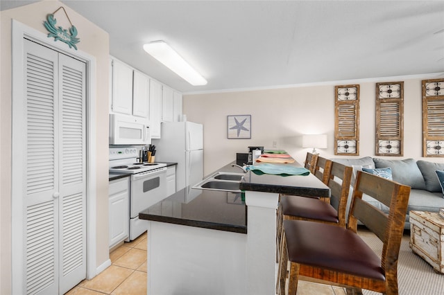 9520 Seawall Blvd Unit 226, Galveston, TX 77554 - kitchen with a breakfast bar, white cabinets, a sink, and white appliances