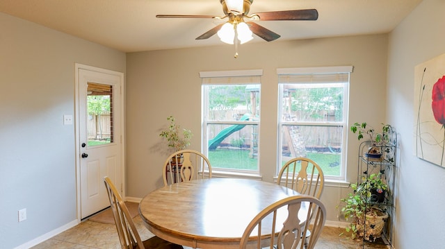 dining space with ceiling fan, plenty of natural light, and baseboards