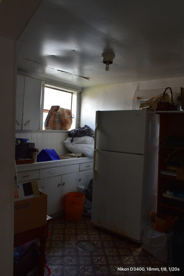 kitchen with white cabinets and freestanding refrigerator