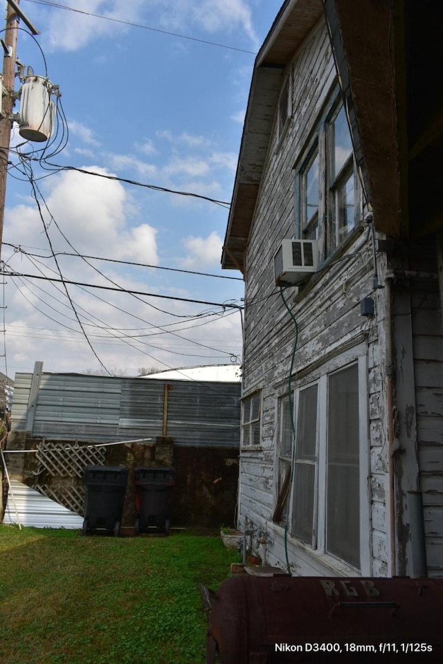 view of side of property with a lawn and cooling unit