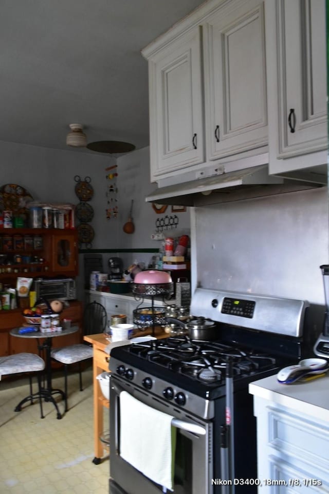 kitchen featuring under cabinet range hood and gas range