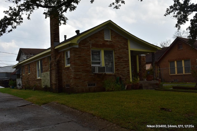 view of front of home with a chimney, a front lawn, and brick siding