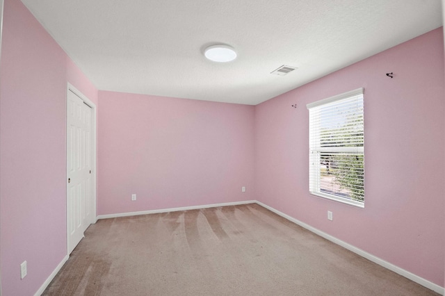 unfurnished room with light carpet, baseboards, and visible vents