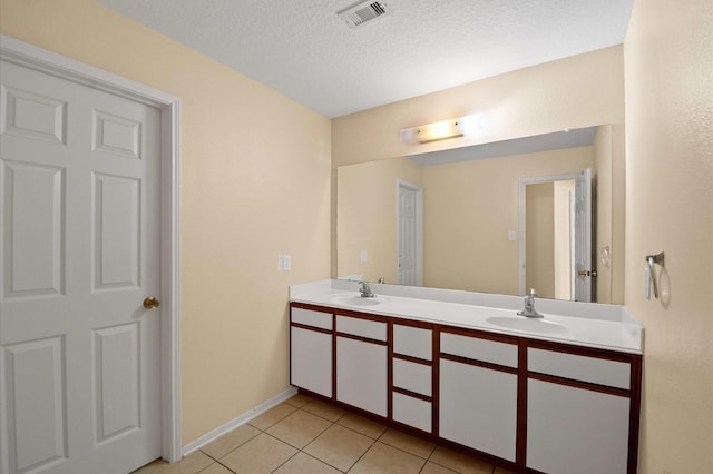 bathroom with double vanity, visible vents, tile patterned flooring, and a sink