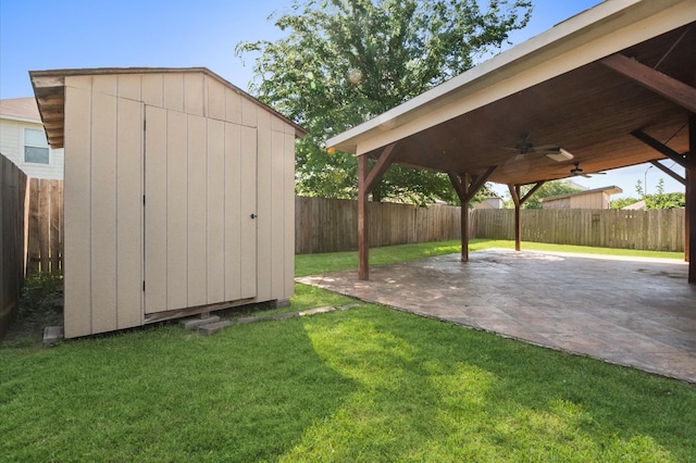 exterior space featuring a storage shed, an outbuilding, a fenced backyard, a ceiling fan, and a patio