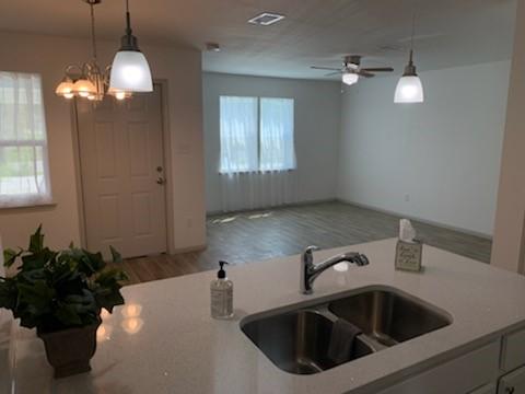 4533 Rosemont St, Houston, TX 77051 - kitchen featuring wood finished floors, ceiling fan with notable chandelier, hanging light fixtures, and a sink