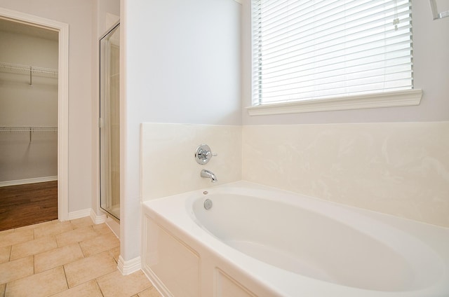 3911 Fallsbrook Ct, Sugar Land, TX 77479 - bathroom with a walk in closet, baseboards, a bath, and a stall shower