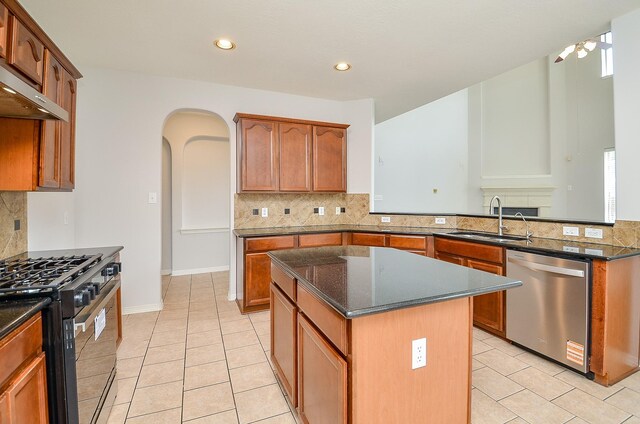 3911 Fallsbrook Ct, Sugar Land, TX 77479 - kitchen with dishwasher, a sink, arched walkways, gas stove, and a center island