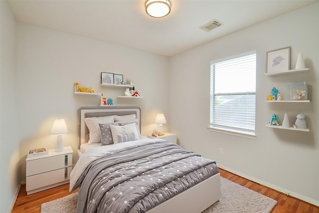3911 Fallsbrook Ct, Sugar Land, TX 77479 - bedroom with baseboards, wood finished floors, and visible vents