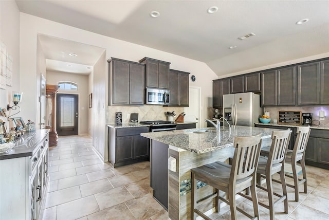22086 Sun Haven Ln, Porter, TX 77365 - kitchen featuring light stone countertops, visible vents, appliances with stainless steel finishes, and tasteful backsplash