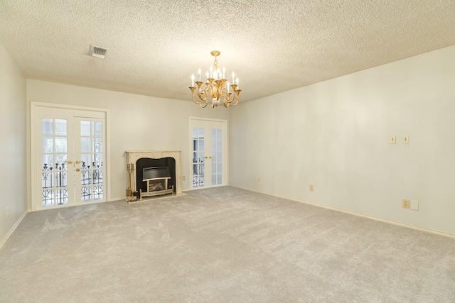 2610 Gerol Ct, Galveston, TX 77551 - unfurnished living room featuring french doors, visible vents, a notable chandelier, a fireplace, and carpet floors
