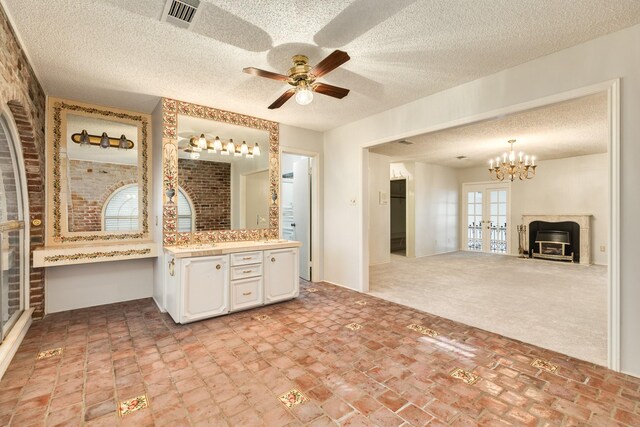 2610 Gerol Ct, Galveston, TX 77551 - bathroom with visible vents, vanity, french doors, a textured ceiling, and ceiling fan with notable chandelier