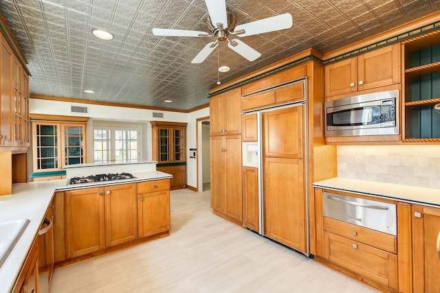 2610 Gerol Ct, Galveston, TX 77551 - kitchen with built in appliances, a warming drawer, brown cabinets, and an ornate ceiling