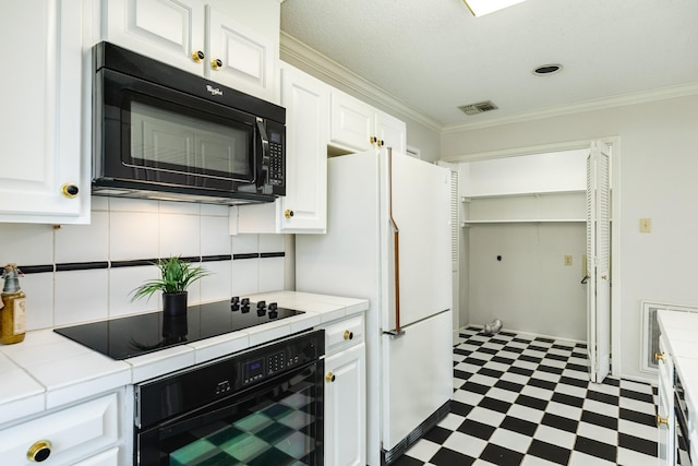 2610 Gerol Ct, Galveston, TX 77551 - kitchen featuring white cabinets, tile patterned floors, tile counters, and black appliances