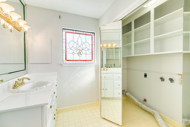 2610 Gerol Ct, Galveston, TX 77551 - bathroom featuring baseboards, a textured ceiling, tile patterned flooring, and vanity