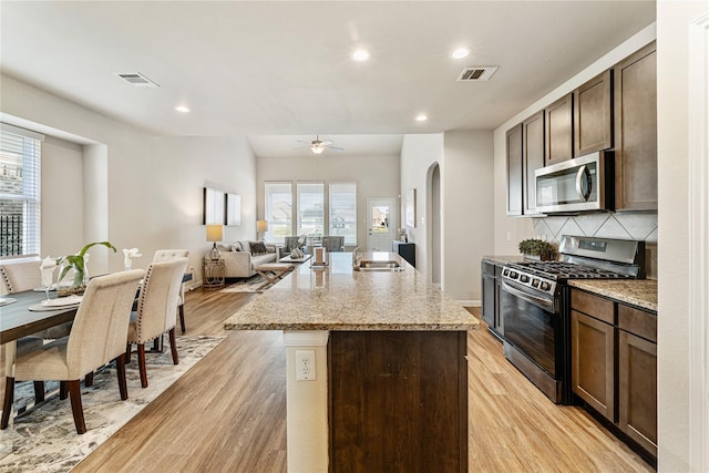 kitchen with visible vents, a sink, light wood-style floors, and appliances with stainless steel finishes