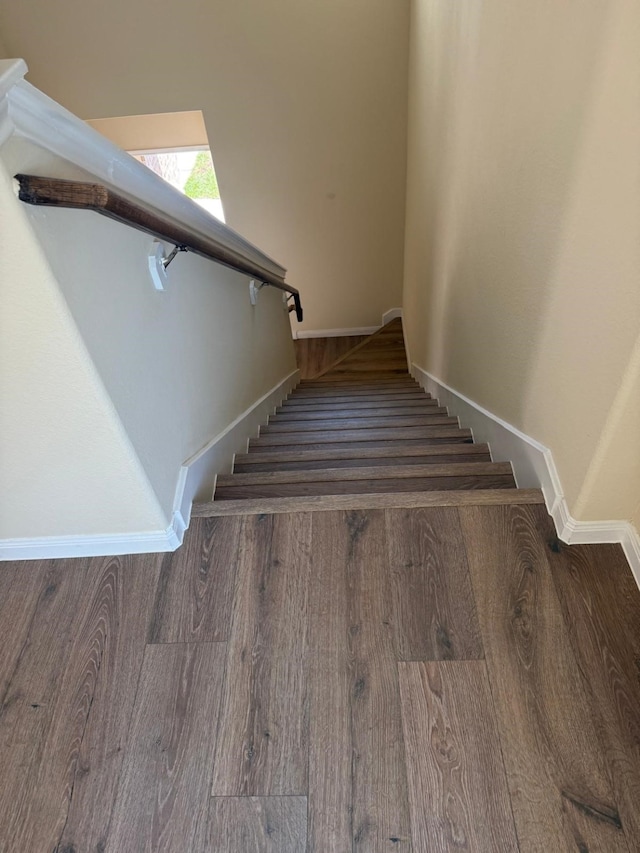 stairs featuring wood finished floors and baseboards