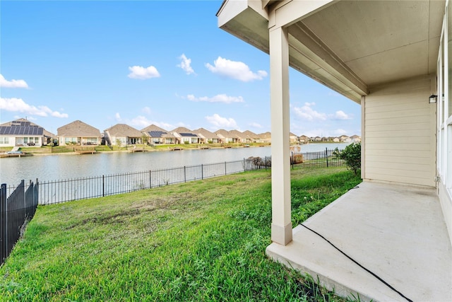 view of yard with a patio, a fenced backyard, a residential view, and a water view