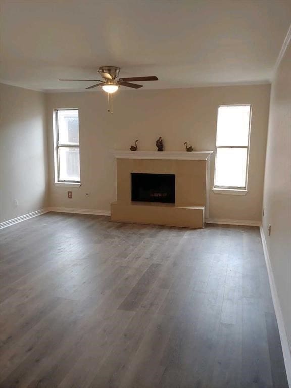 10555 Turtlewood Ct Unit 607, Houston, TX 77072 - unfurnished living room with a fireplace with raised hearth, wood finished floors, a ceiling fan, crown molding, and baseboards