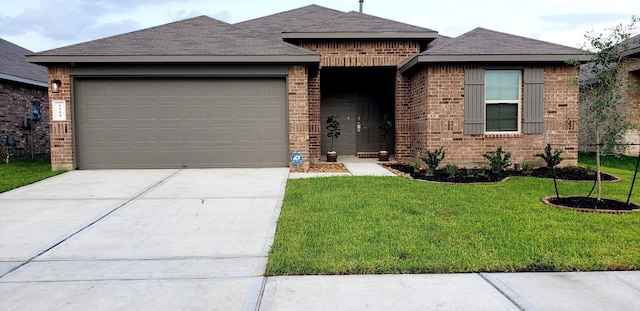 view of front facade featuring roof with shingles, concrete driveway, brick siding, a front yard, and a garage