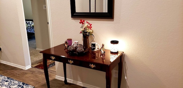 room details with baseboards, a textured wall, and wood finished floors