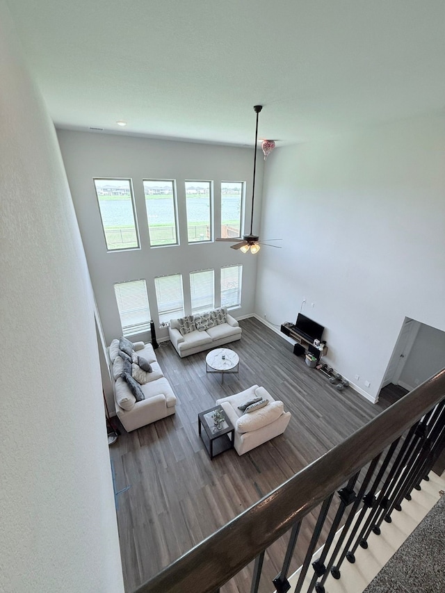 living room with stairway, baseboards, ceiling fan, and wood finished floors