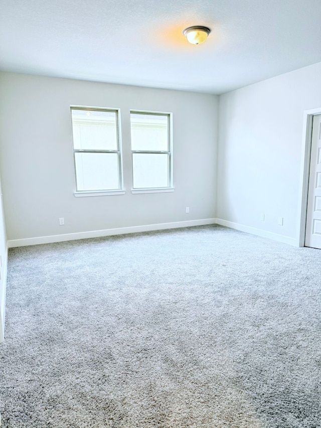 carpeted spare room with baseboards