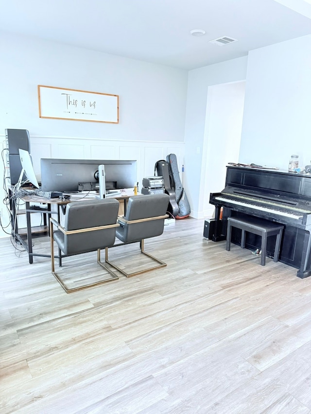 living area featuring visible vents and wood finished floors