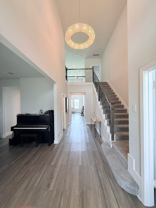 foyer with baseboards, a high ceiling, wood finished floors, and stairway