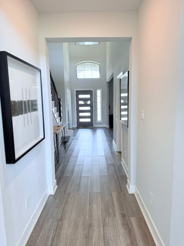 interior space with baseboards, wood finished floors, and stairway