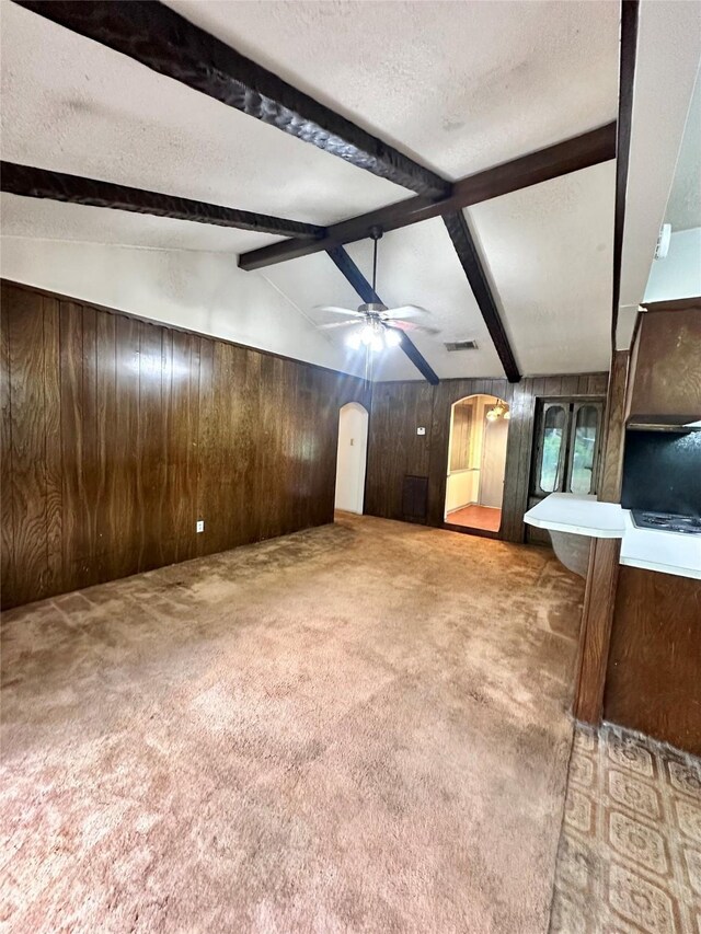 597 County Road 605, Angleton, TX 77515 - unfurnished living room with lofted ceiling with beams, wood walls, carpet floors, and ceiling fan