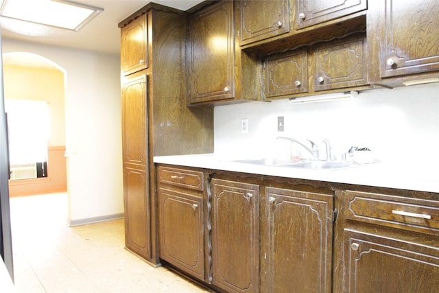 597 County Road 605, Angleton, TX 77515 - kitchen featuring baseboards, light countertops, a sink, and arched walkways