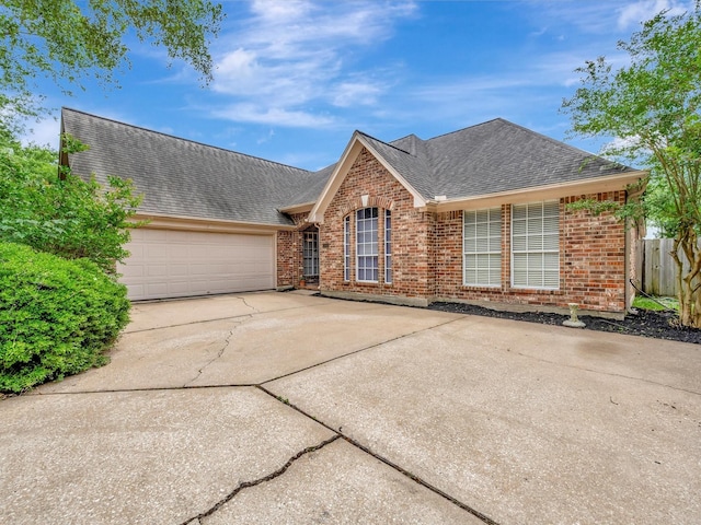 single story home featuring brick siding, driveway, a shingled roof, and a garage