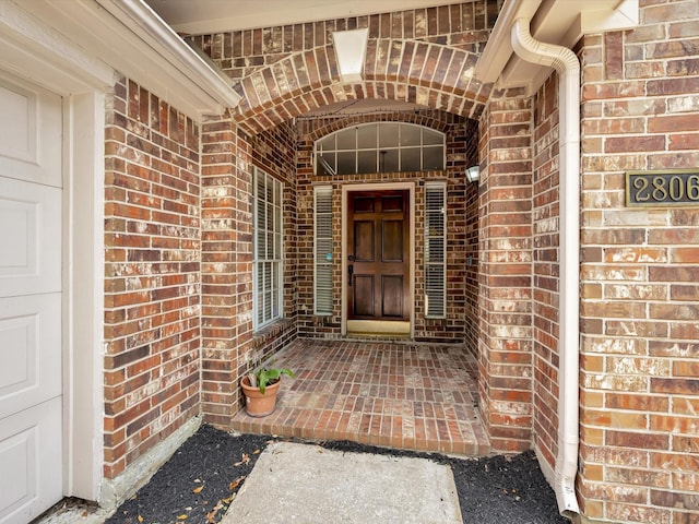 doorway to property featuring brick siding