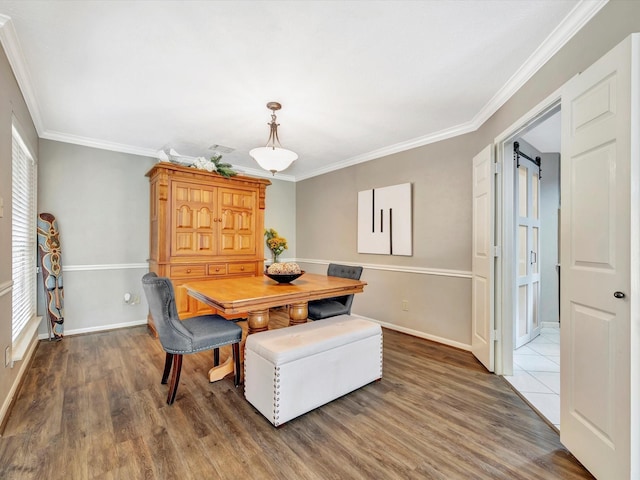 2806 Village Dl, Houston, TX 77059 - dining room with wood finished floors, ornamental molding, baseboards, and a barn door