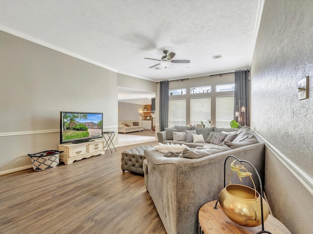 2806 Village Dl, Houston, TX 77059 - living room featuring a ceiling fan, a textured ceiling, wood finished floors, ornamental molding, and a textured wall