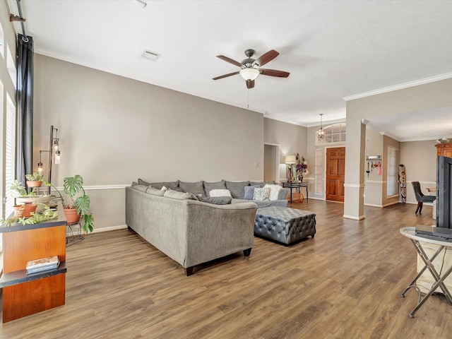 living room with ceiling fan, baseboards, crown molding, and wood finished floors