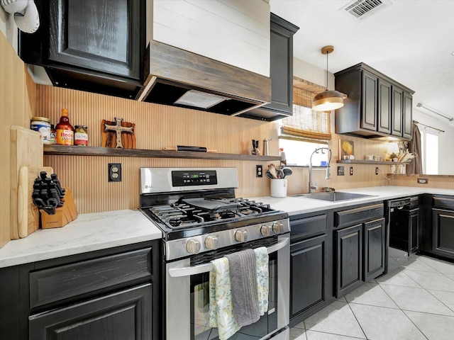 2806 Village Dl, Houston, TX 77059 - kitchen with stainless steel gas range oven, a sink, light tile patterned floors, healthy amount of natural light, and wooden walls
