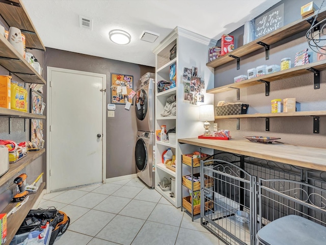 2806 Village Dl, Houston, TX 77059 - laundry area featuring stacked washer and clothes dryer, light tile patterned floors, and baseboards