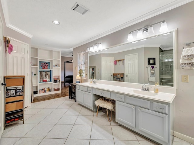 bathroom featuring double vanity, visible vents, a sink, and ornamental molding