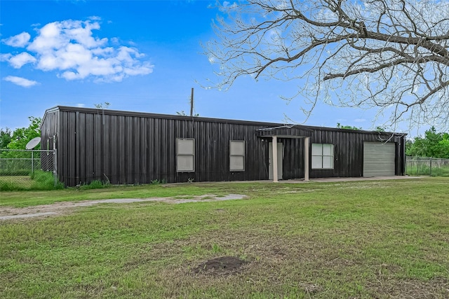 view of pole building featuring a yard and fence