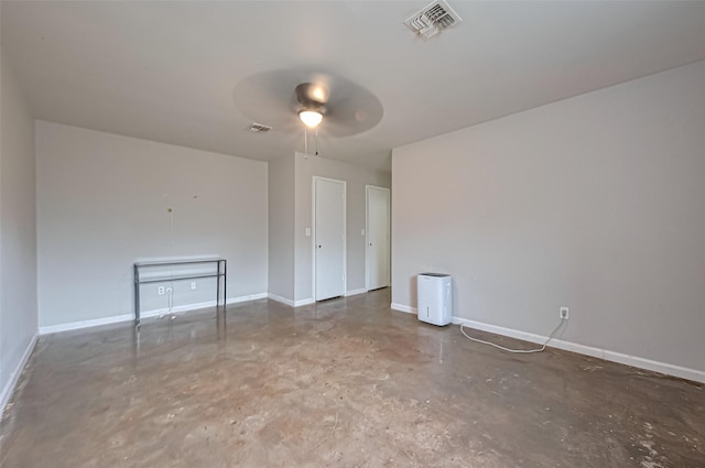 empty room featuring visible vents, baseboards, concrete flooring, and ceiling fan