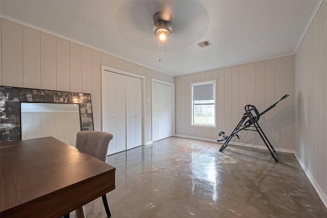 unfurnished office with ceiling fan, visible vents, concrete flooring, and crown molding