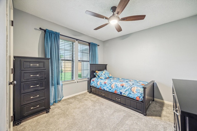 bedroom with a textured ceiling, carpet flooring, ceiling fan, and baseboards